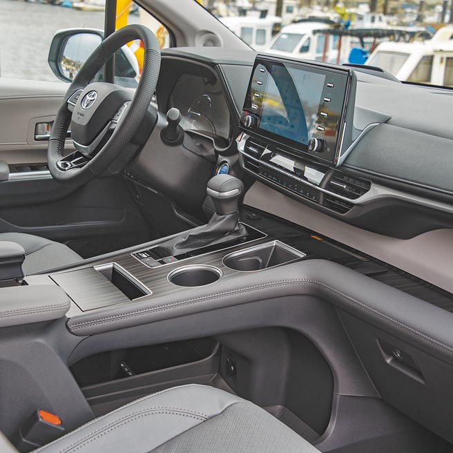 仪表控台以皮革搭配木纹展现奢华感，T字造型排檔座的前方为手机无线充电板，排檔杆右侧、后方及下方为多样化置物设计。（陈大任摄）