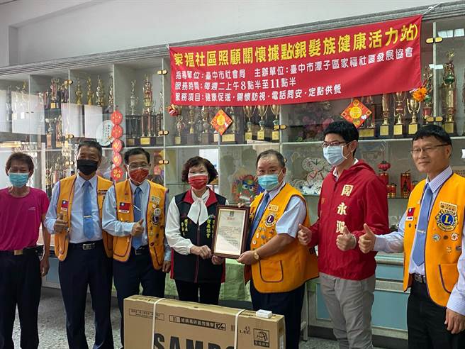 大地獅子會由會長沈育庭代表捐贈電視，李新妹代表關懷據點接下這份大禮。（市議員周永鴻服務處提供）