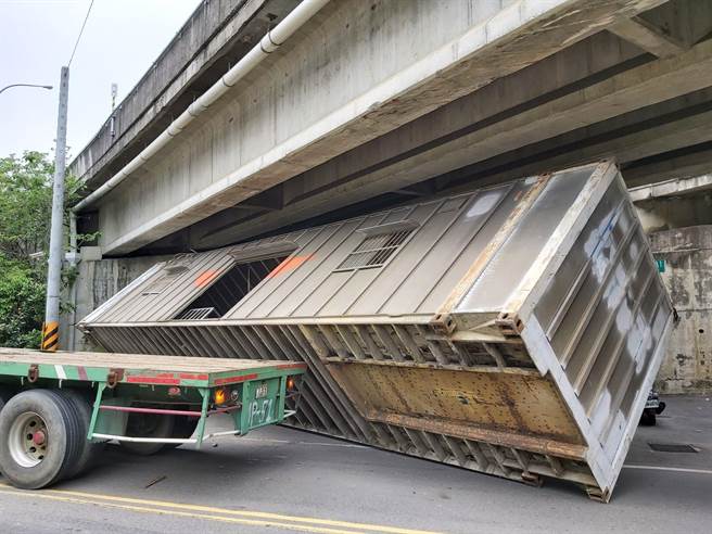 拖板車載運貨櫃屋，行經頭份市興隆路、國道1號下方涵洞，撞擊涵洞頂翻落。（讀者提供／何冠嫻苗栗傳真）