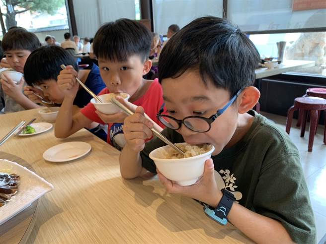 喷水鸡肉饭小雅店负责人董孟婷在儿童节前夕，招待百名兰潭国小学生享用鸡肉饭圆桌餐，今30日中午学童们大口吃着鸡肉饭，直呼又香又好吃！（吕妍庭摄）