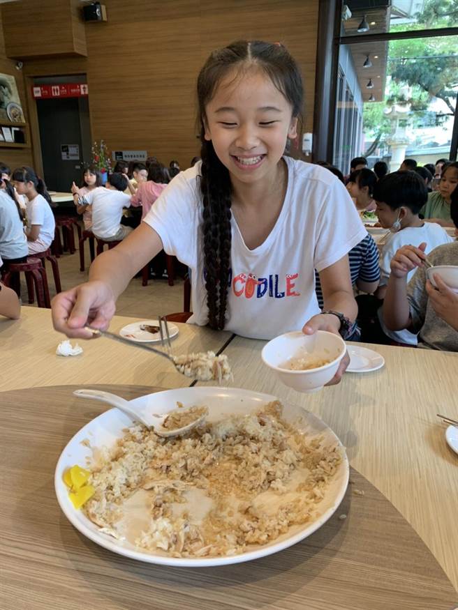 喷水鸡肉饭小雅店负责人董孟婷在儿童节前夕，招待百名兰潭国小学生享用鸡肉饭圆桌餐，今30日中午学童们大口吃着鸡肉饭，直呼又香又好吃！（吕妍庭摄）