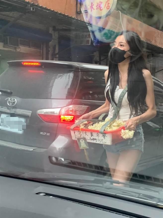 大眼正妹在路边卖玉兰花，亮丽的外型在车阵中特别显眼。(图取自爆废1公社)