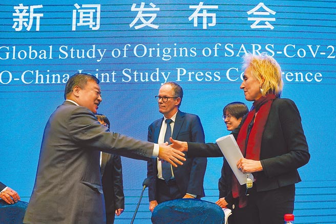 世界衛生組織國際專家小組今年2月9日在武漢舉行新聞發布會，發布會結束後，專家小組中方組長梁萬年與其他成員握手道別。世衛專家小組在武漢進行的病毒溯源調查報告即將公布。（美聯社）