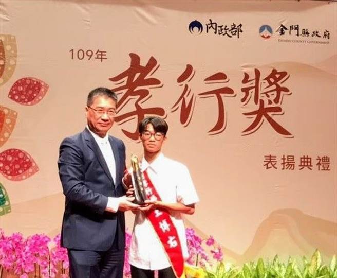 内政部长徐国勇颁发全国孝行奖杯予王博右同学。(图/内政部提供)