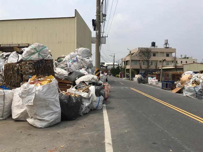 台中市大甲區文曲路59巷兩側路肩被成堆回收物攻佔，部分太空包堆疊1層樓高。（王文吉攝）