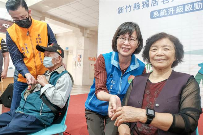 縣府祕書長陳季媛（右二）為獨居老人戴上有通報功能的GPS手錶。（羅浚濱攝）