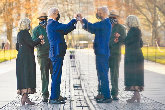 美國總統拜登（右）29日偕第一夫人吉兒（左）前往首都華盛頓的越戰紀念碑獻花，以紀念「越戰退伍軍人節」。圖為拜登夫婦在紀念碑上找尋一名越戰陣亡美軍的名字。（美聯社）