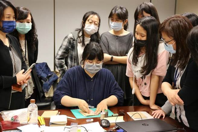 （中华开发呈现人才培育成果。古物维护研究所潘同学，指导同仁以缝线装订书册的古老技艺。图／中华开发提供）