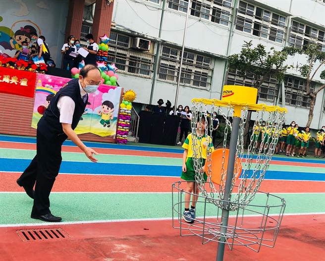 台中市教育局長楊振昇拋擲出手中飛盤，敲響高爾夫球柱後，宣布啟用典禮正式開始。（富春國小提供／王文吉台中傳真）