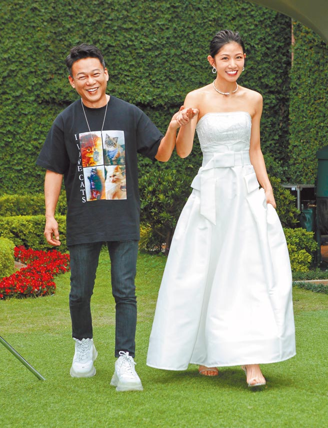 李康生（左）展現紳士風度，昨牽著穿白紗禮服的李千那出場。（吳松翰攝）