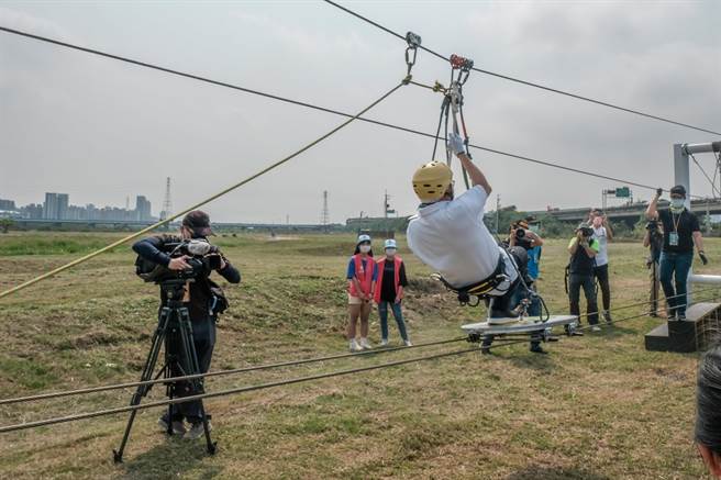 桃園市長鄭文燦體驗「空中滑板」，突然重心不穩身體後仰，演出高難度下腰動作。（羅浚濱攝）