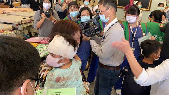 逃過一劫的小朋友驚魂未定，身上衣服還沾有血跡。（羅亦晽攝）