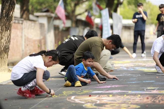 台中市勞工局在光復新村青創基地舉辦地景彩繪活動，現場許多父母帶著孩子共同創作，為孩子留下難忘的兒童節回憶。（馮惠宜攝）