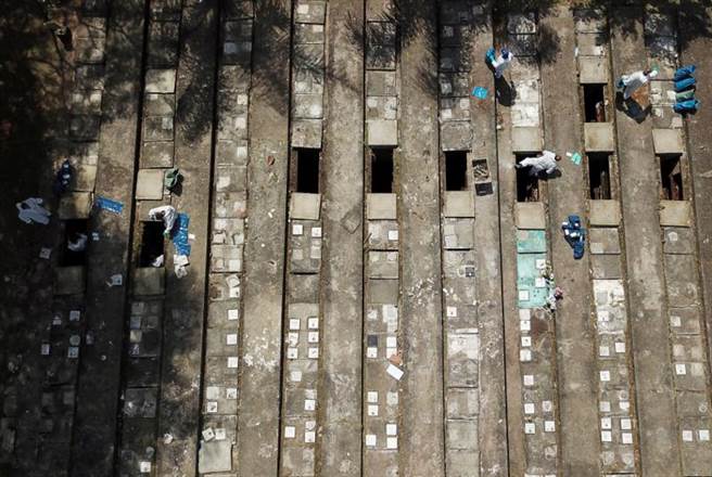 巴西圣保罗加速清空老坟，为激增的染疫病故者腾出掩埋空间。（图／路透社）