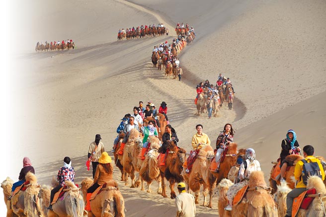 大陆把清明与五一假期视为内需旅游市场復甦的重要观察点。图为甘肃敦煌鸣沙山月牙泉景区，以往五一假期挤满旅客。（新华社）