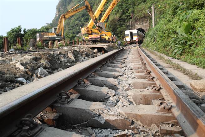 台铁太鲁阁号在花莲撞上工程车出轨意外，3日现场工作人员开始吊起第二节车厢，希望能将车厢放回正常的轨道中再拖走。（郑任南摄）