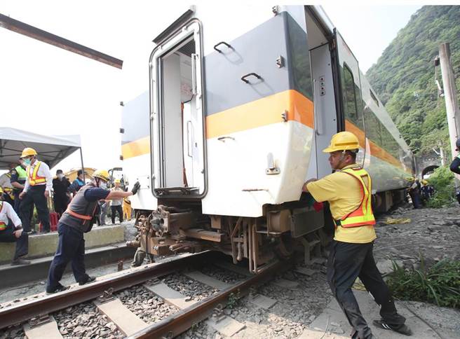 台铁太鲁阁号在花莲撞上工程车出轨意外，3日现场工作人员开始吊起第二节车厢，放回正常的轨道慢慢与一号车厢连接后拖离现场。（郑任南摄）