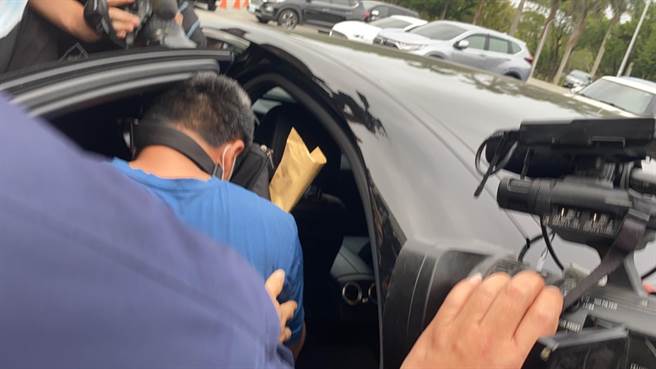 李义祥搭乘友人的黑色宾士车前，因为被许多媒体记者挡住去入，低声说2句「对不起」。（罗亦晽摄）