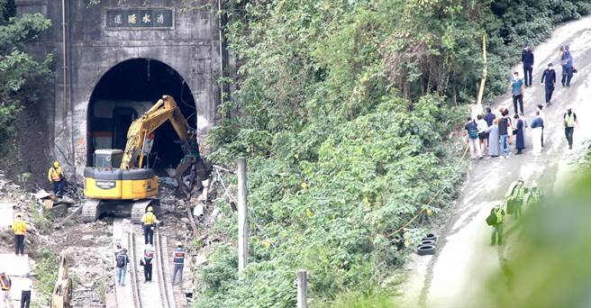 台鐵太魯閣號在花蓮撞工程車出軌意外，4日現場在第三節車廂脫走後，工作人員開著怪手進入隧道清理隧道中的殘骸，同時仍有罹難家屬帶著招魂幡到現場招魂。（鄭任南攝）