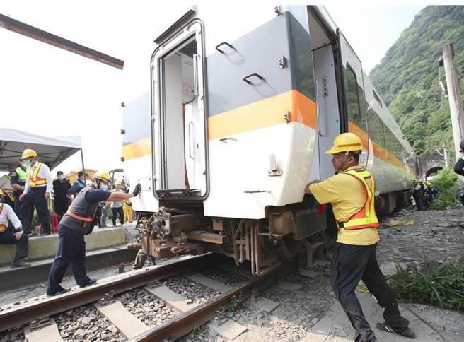 台铁太鲁阁号在花莲撞上工程车出轨意外，3日工作人员将第二节车厢拖离现场。（郑任南摄）