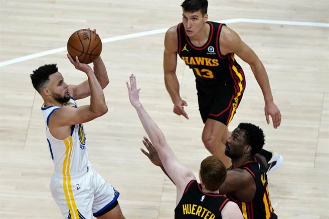 就算两名老鹰球员扑上来防守，勇士后卫柯瑞仍然后仰出手。(美联社)