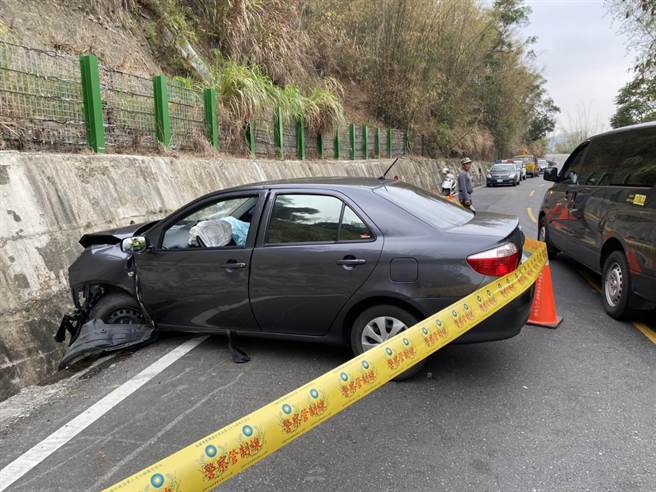 一輛轎車在與一輛休旅車發生擦撞後，撞擊路旁山壁，警方到場拉起封鎖線蒐證。（翻攝照片／林瑞益高雄傳真）