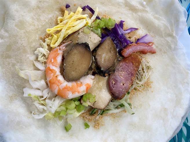 家住福隆漁港旁的詹資東嘗試將貢寮鮑與傳統潤餅做結合，開發出美味又有特色的貢寮鮑潤餅。（新北市漁業處提供／葉書宏新北傳真）