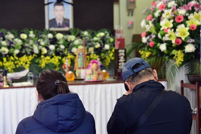 陈品全的遗照穿着帅气的军装，陈父低头频拭泪。（庄哲权摄）