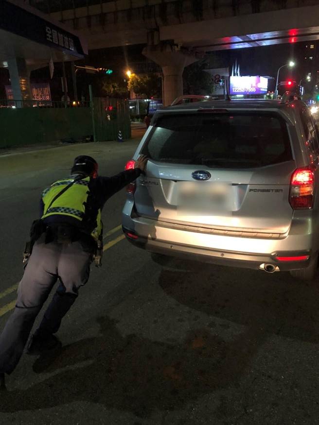 黄员使出洪荒之力，单臂协助车主将车辆推移至路旁。（警方提供）