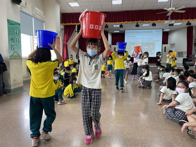 嘉义市精忠国小学生体验抬水取水之不便。（精忠国小提供）