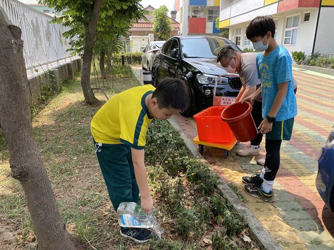 嘉义市精忠国小学生用回收水浇灌植栽。（精忠国小提供）