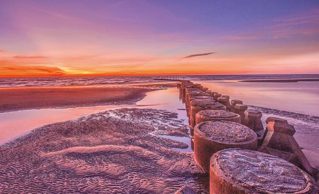 鳳坑漁港退潮時，落日餘暉美景。（羅浚濱攝）