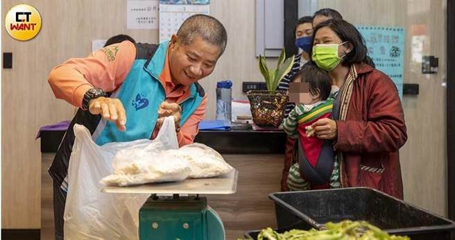 高雄市警局三民二分局交通分队小队长黄振郎，每逢休假就到食物银行帮忙分发物资，面对每个来领取的民眾都温柔招呼，让人备感窝心。（图／宋岱融摄）