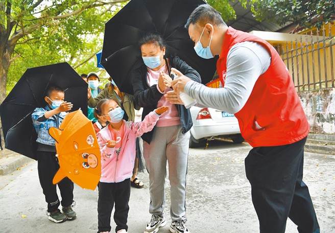 云南省瑞丽市再增2例本土病例，云南省现40.3万人完成两剂接种，仅占云南约4800万常住人口的0.8％。图为当地居民进行手部消毒。（新华社）