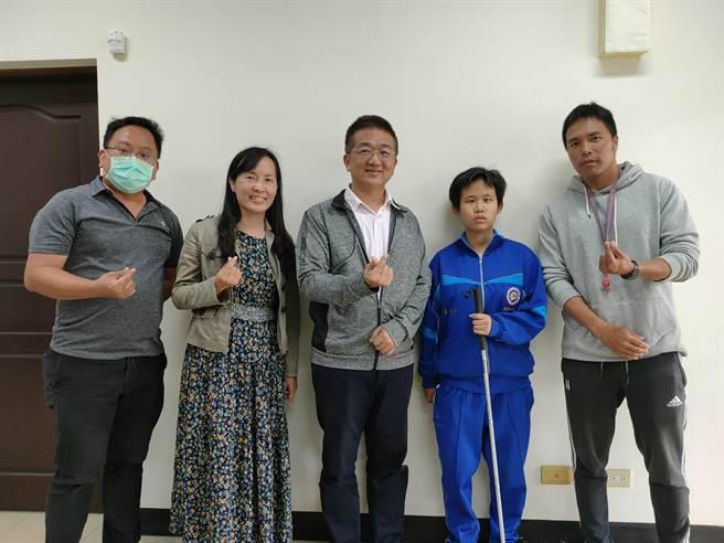 柯妤蓁(右2)是患有先天性雙眼視神經萎縮的盲生，在老師與同學的鼓勵下，順利完成人生中第一場大隊接力比賽，開心與黃洲海校長(中)、班導師周婉淑(左2)、體育老師黃宏凱(右1)，及父親林廷宇(左1)合影。(吳建輝攝)