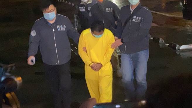 义祥工业社负责人李义祥（中），8日晚间身穿黄色囚服，手部上铐由检警戒护前往花莲地检署问讯。（记者／罗亦晽摄）