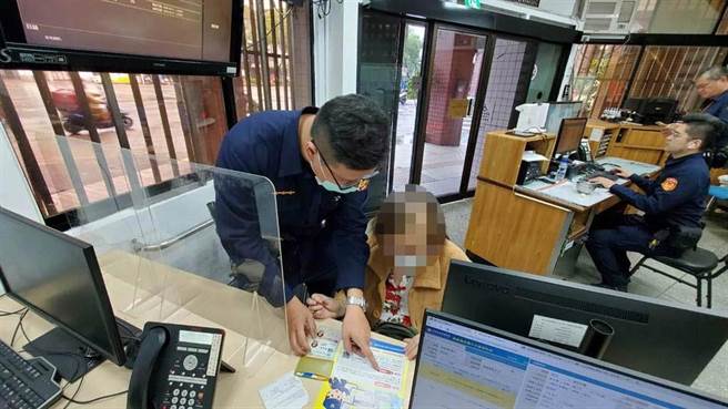 林员耐心向老妇解说假检警的诈骗手法，老妇才惊觉遇到诈骗集团。（翻摄照片／林郁平台北传真）
