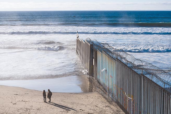 位在美墨邊境的墨西哥城市蒂華納海岸邊，一堵數米高的邊境圍牆從海水中豎起，向東延伸，不見盡頭。這裡是美國和墨西哥邊境圍牆的起點，曾有不少非法移民於夜間從這裡泅水前往美國，但由於風大浪急，不少人丟了性命。（新華社）