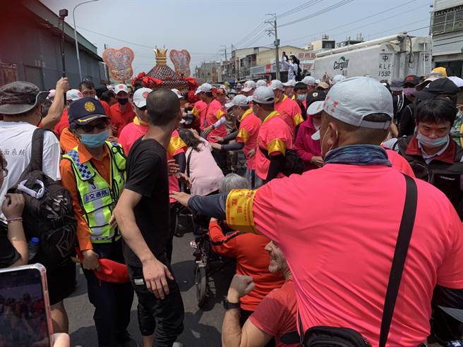 大甲镇澜宫妈祖銮轿在大肚区沙田路一处民宅外，特别开放给坐轮椅的老人钻轿底。(林欣仪摄)