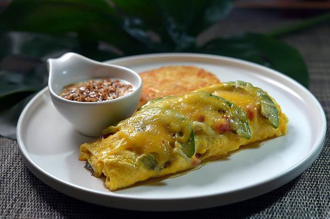 〈M One Cafe〉的〈什錦蛋捲〉很 有「內涵」，歐姆蛋內捲了洋蔥、洋菇、番茄、酪梨、火腿與培根和起司。（圖／姚舜）