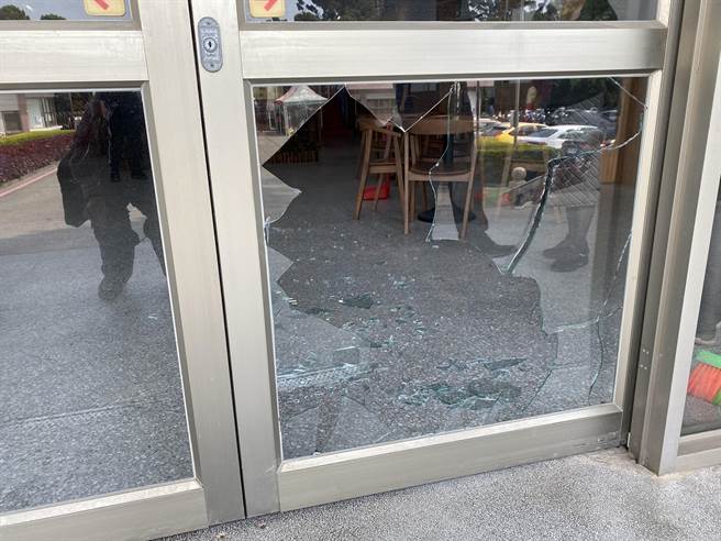 大门落地窗遭砸，玻璃破了一大块，碎片散落一地。（读者提供）