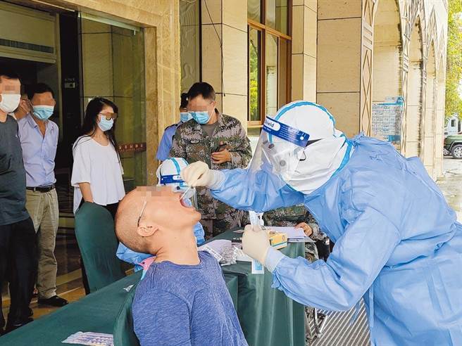 大陆云南省瑞丽市13日完成第三轮全员核酸检测。示意图，大陆医护人员对瑞丽市玉瑞温泉花园酒店的入住人员进行核酸检测。（中新社）