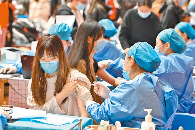 专家比较多国疫情趋缓的关键因素指出，疫苗普及率和防疫措施同样重要。图为内蒙古工业大学学生在接种疫苗。（中新社）