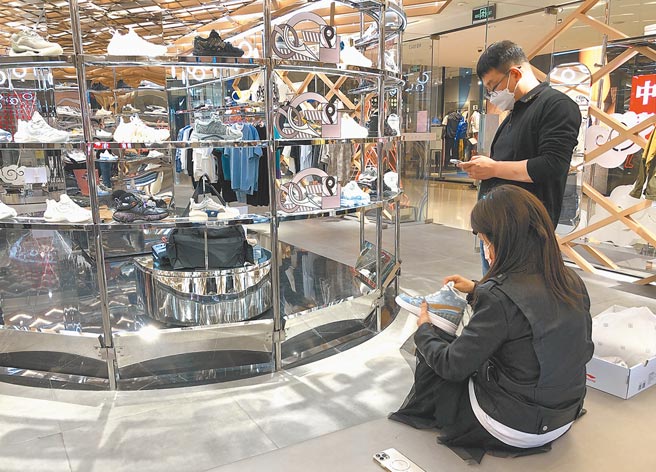 因抵制外国体育品牌风波，让大陆掀起炒鞋风，尤以炒作大陆国产鞋。图为北京一间李寧门市，一名女顾客正试穿球鞋。（许依晨摄）