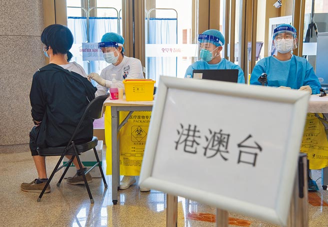 大陆国台办宣布在大陆的台湾民眾，接种大陆疫苗方案，原则与大陆居民一样，都免费，优于港澳居民，只要有台胞证即可免费施打。图为一名在北京清华大学就读的港澳台学生在校内接种新冠疫苗。（中新社）