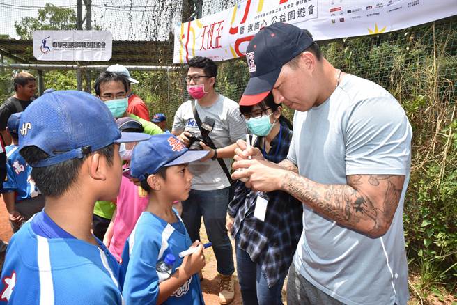 前旅美左投名將郭泓志（右）17日參加天使盃棒球體驗賽，他為孩子們簽名。（林瑞益攝）