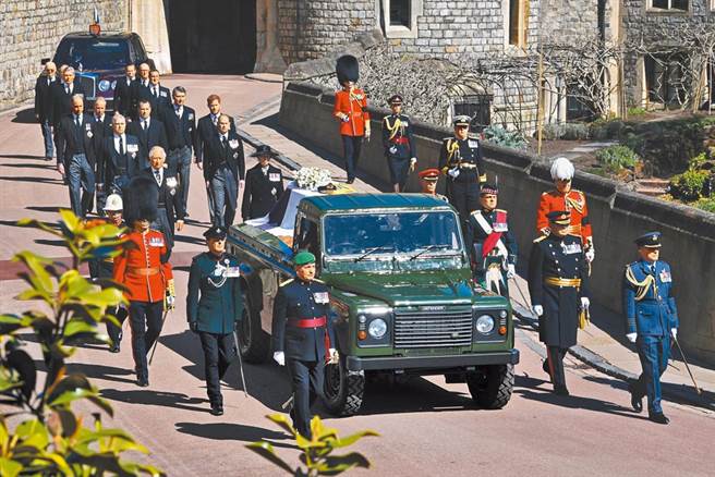 英国王室成员由王储查尔斯(中)带头，率领弟弟约克公爵安德鲁王子等手足，以及儿子威廉和哈利，跟随菲利普亲王生前参与设计、由路华吉普车改装的灵车，徒步前往圣乔治教堂。（路透）