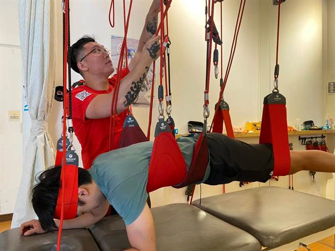 趙嘉豪老師使用紅繩懸吊系統進行治療，檢測身體的肌力平衡。（柯宗緯翻攝）