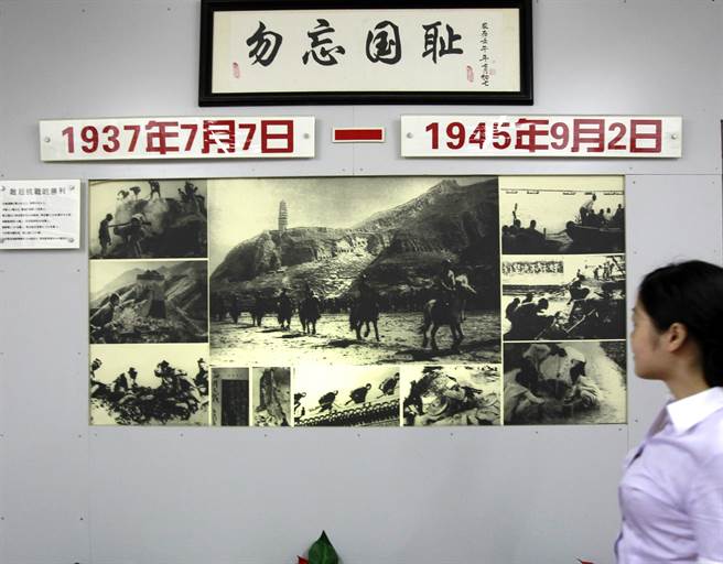 上海四行倉庫八百壯士英勇抗日事跡陳列室的工作人員在陳列的照片資料前駐足。（新華社）