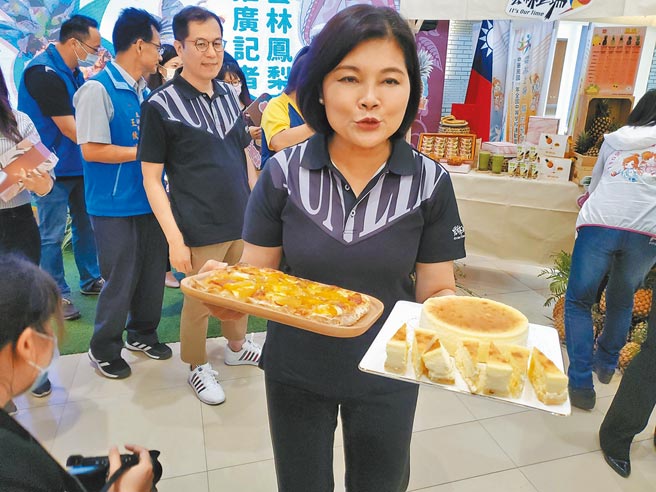 云林县长张丽善20日一手端凤梨乳酪、一手端凤梨披萨招呼大伙享用。（周丽兰摄）